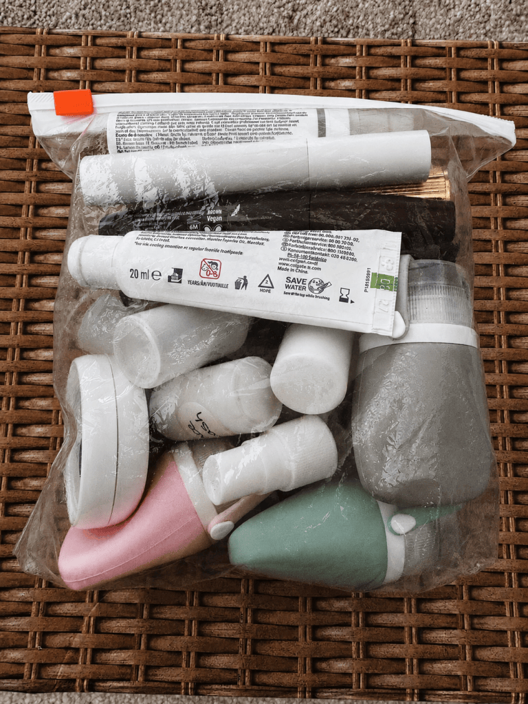 Full skincare and toiletry routine packed inside a transparent 15cm by 15cm travel liquids bag, with room remaining.