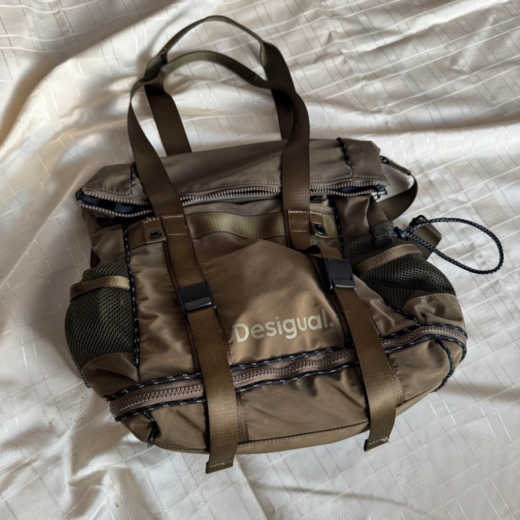     Base of the Desigual Voyager XL bag zipped closed at its standard size.